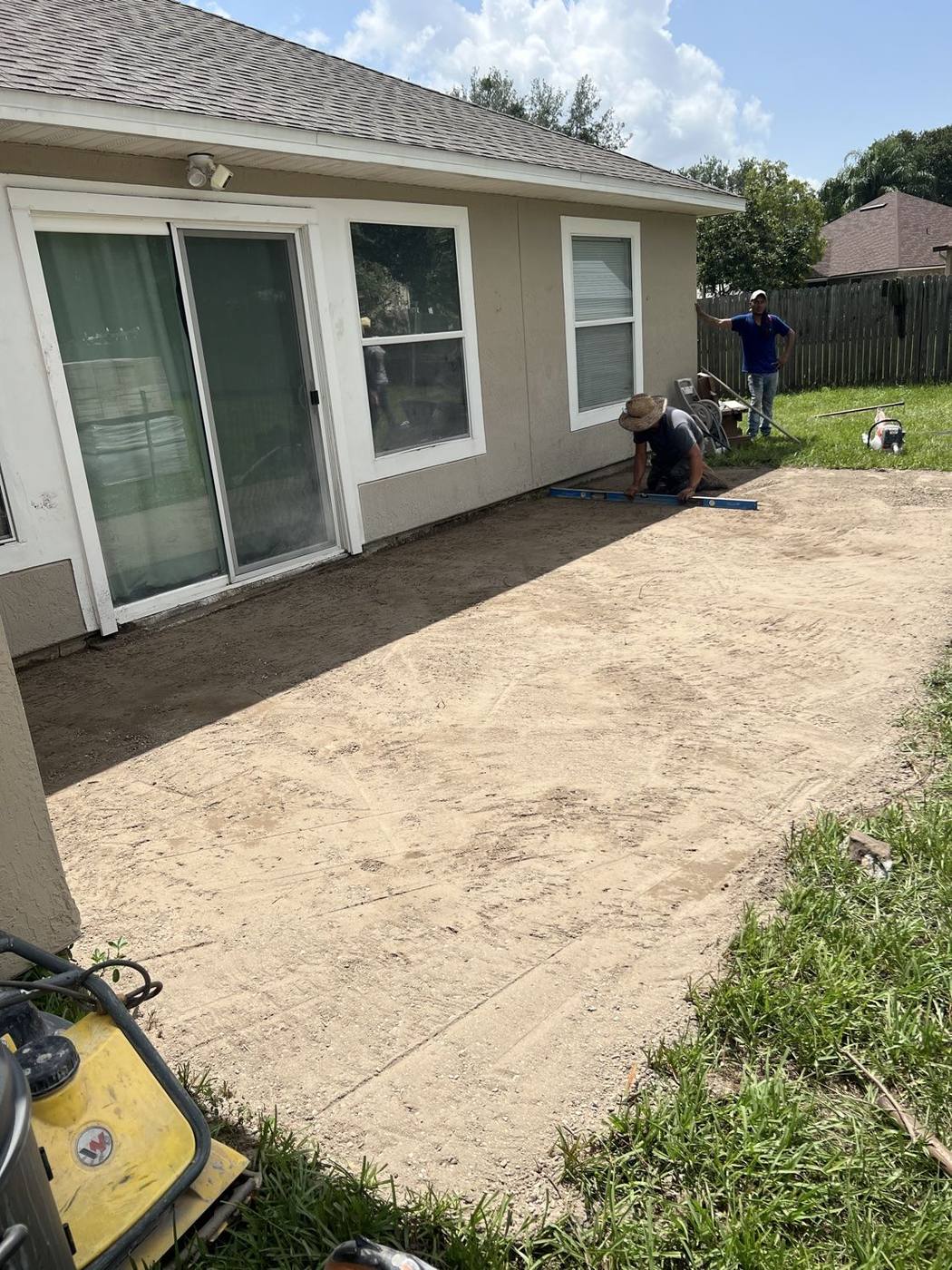 Crew laying patio pavers in the prepared base