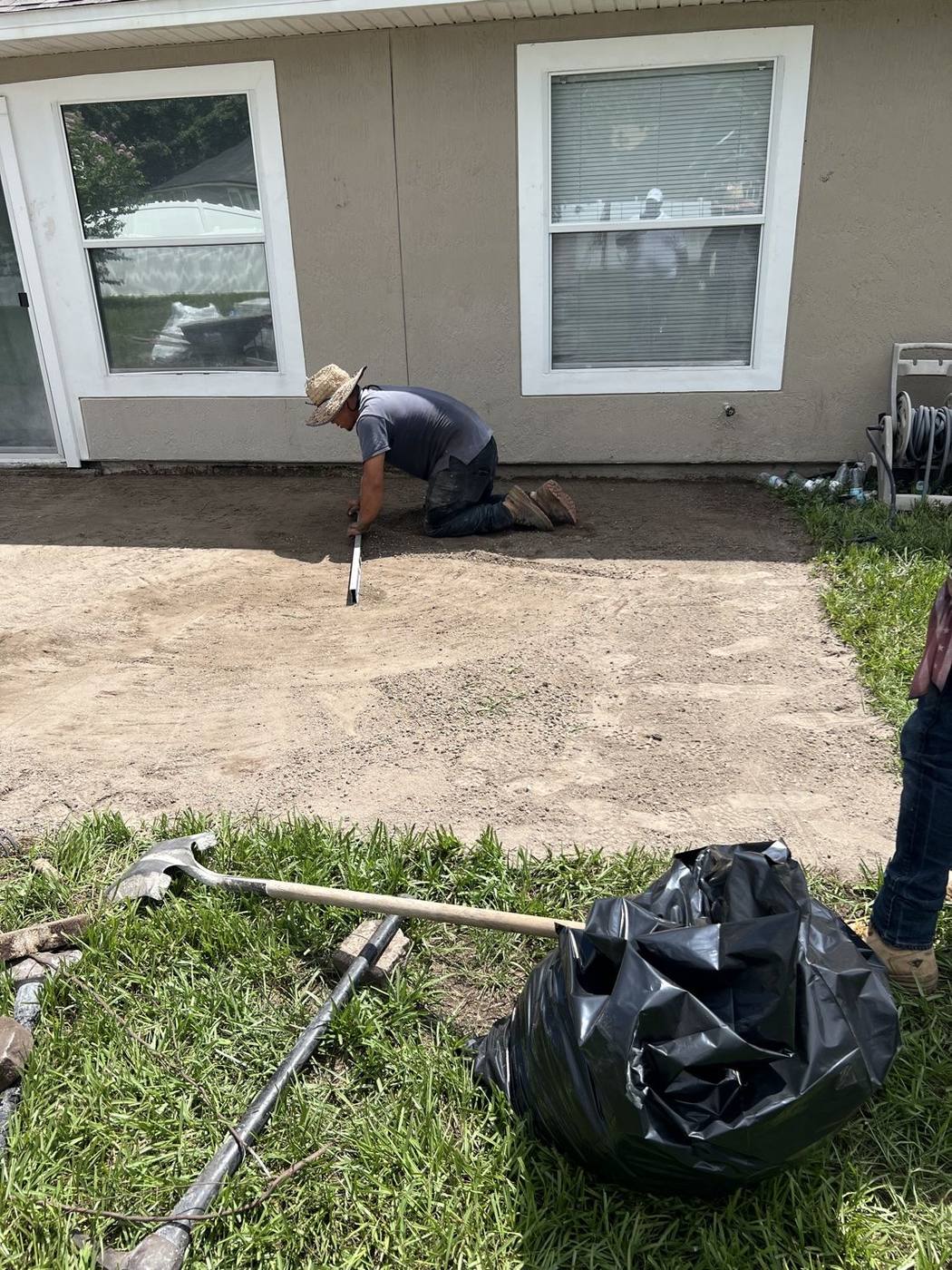 Crew leveling the patio base before paver installation