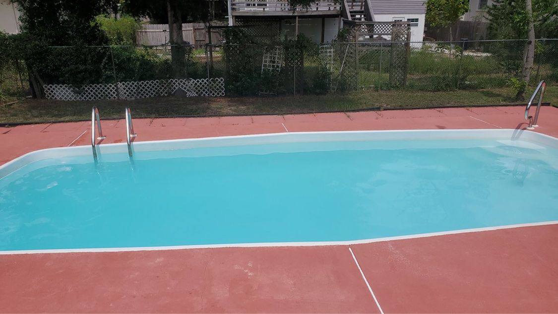Same rectangular pool with crystal-clear blue water after treatment